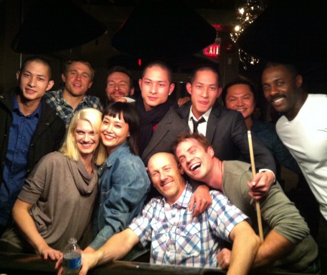 A group of smiling adults and instructors gathering for a community social event and adult martial arts networking night.