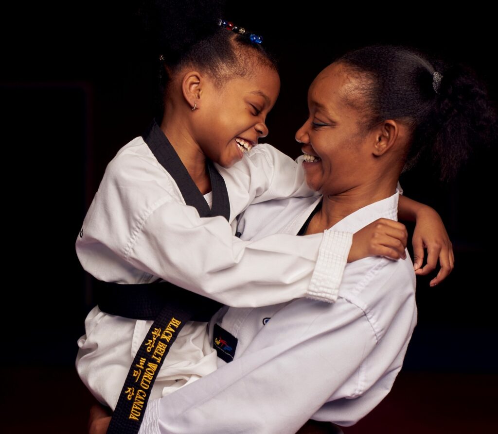 A happy female instructor hugging a young student to promote emotional well-being and positive mentorship.