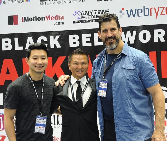 Our Master Instructor posing with Marvel star Simu Liu at a martial arts industry event for professional stunt performers.